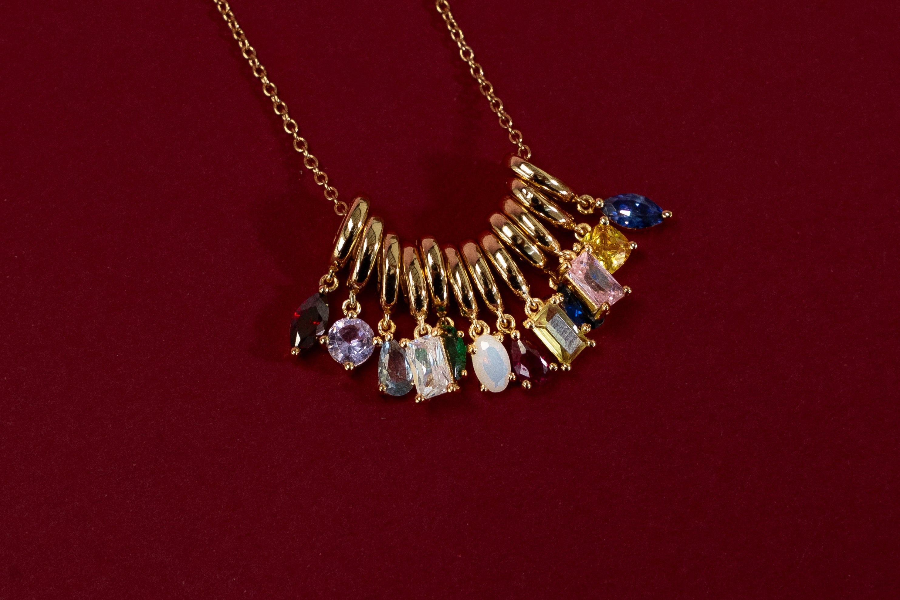 Necklace with colorful gemstones on a red background