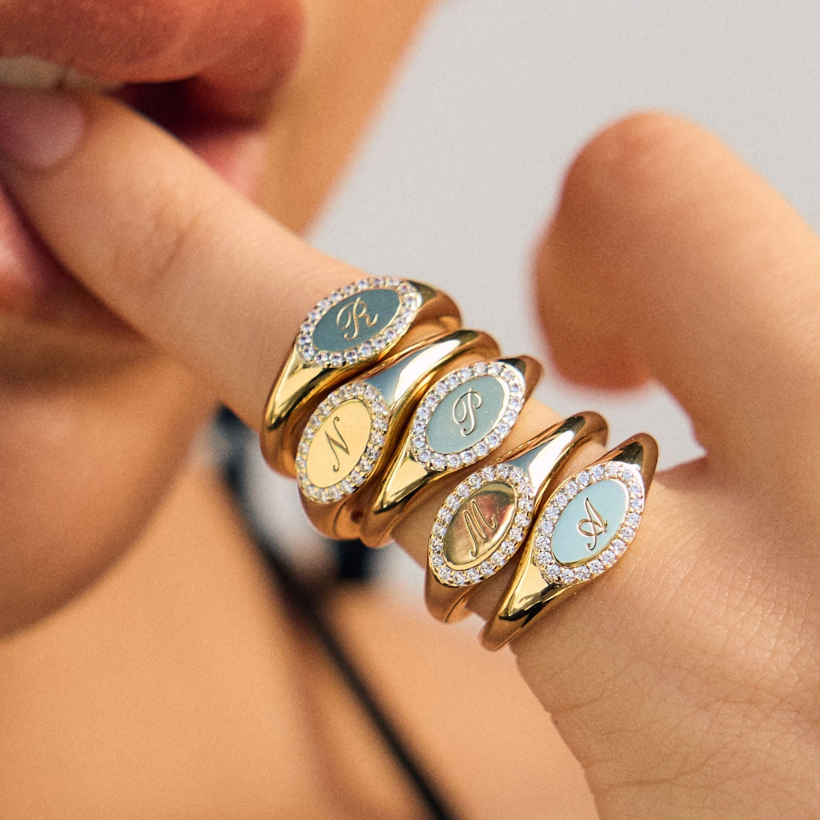 Close-up of a hand wearing multiple gold rings with gemstones.