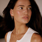 Woman wearing a white sleeveless top with a blurred background