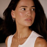 Woman wearing a white sleeveless top with a blurred background