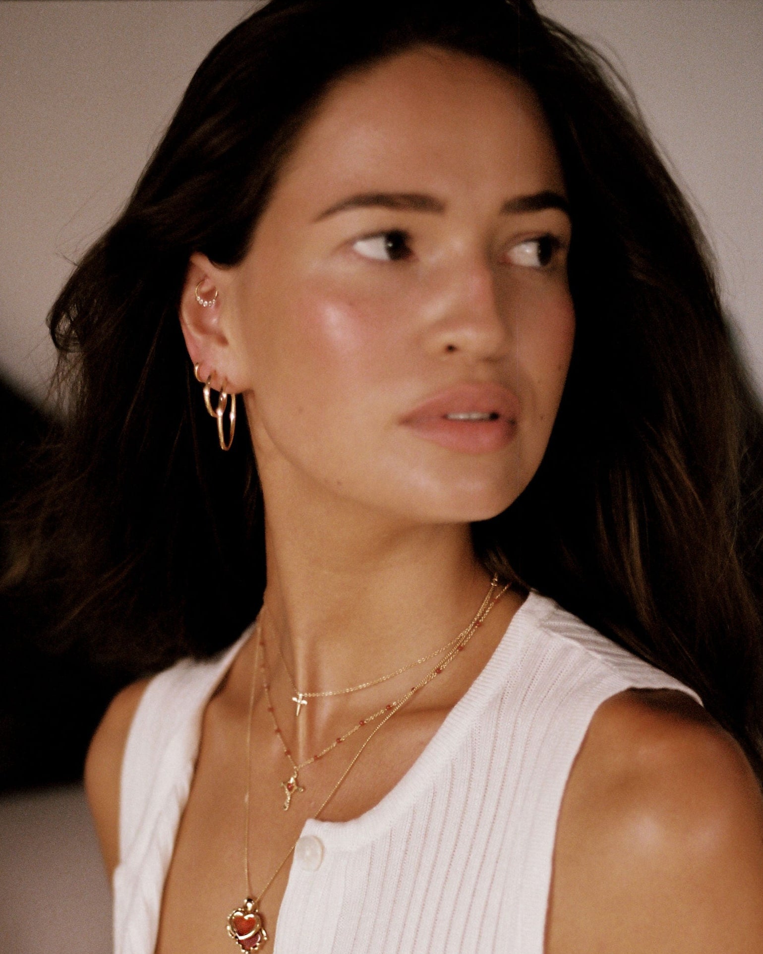 Woman wearing a white sleeveless top with a blurred background