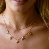 Close-up of a woman wearing a gold necklace with pendant