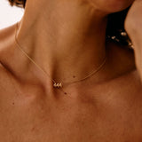 Close-up of a person wearing a gold necklace with the number '444'.