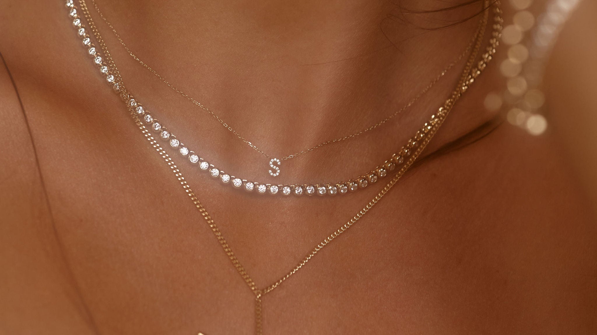 Close-up of a person wearing gold necklaces with a blurred background