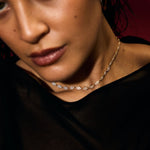 Close-up of a person wearing a delicate evil eye tennis necklace