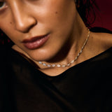 Close-up of a person wearing a delicate evil eye tennis necklace