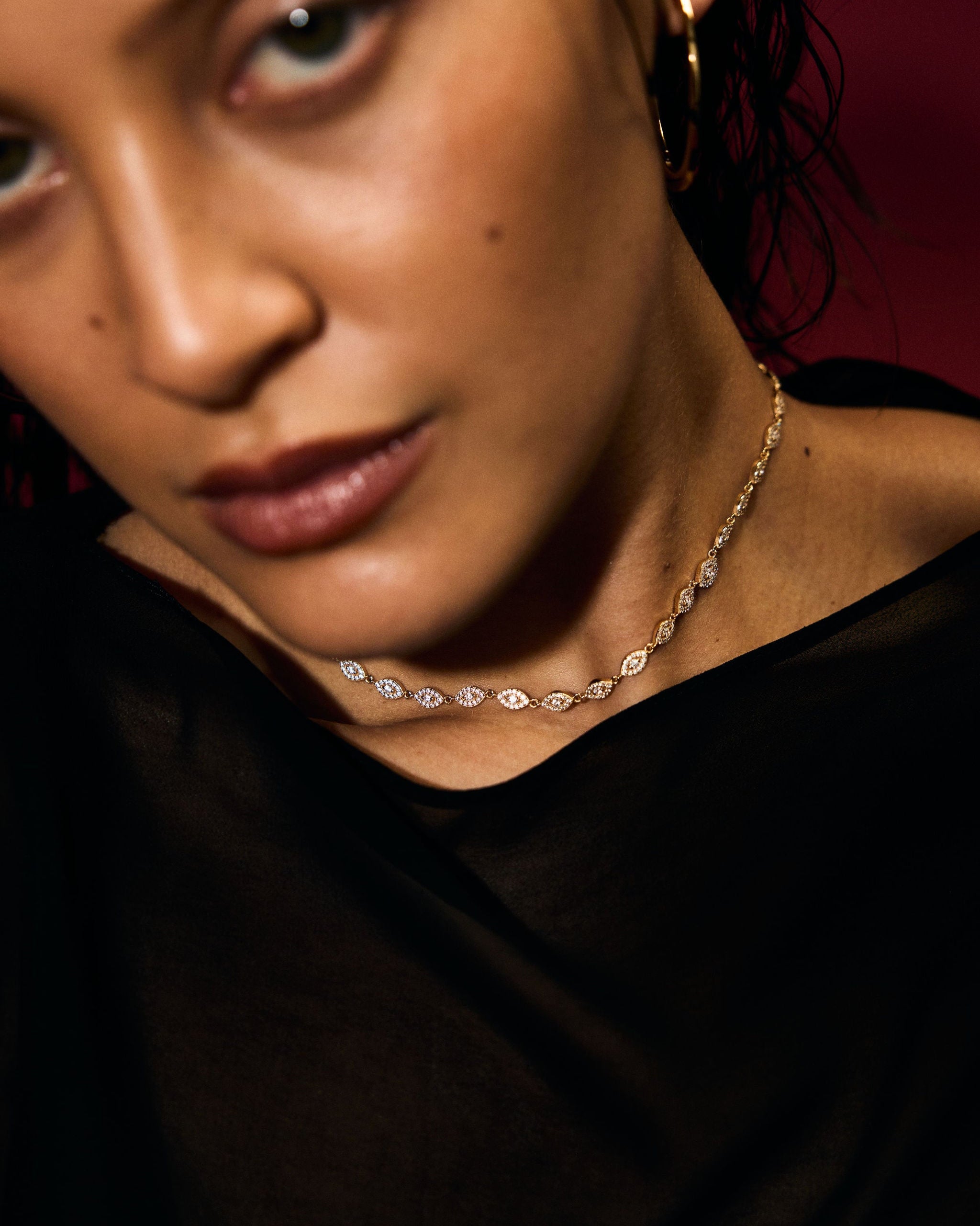 Close-up of a person wearing a delicate evil eye tennis necklace