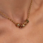 Gold necklace with colorful beads on a person's neck