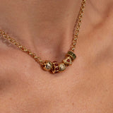 Gold necklace with colorful beads on a person's neck