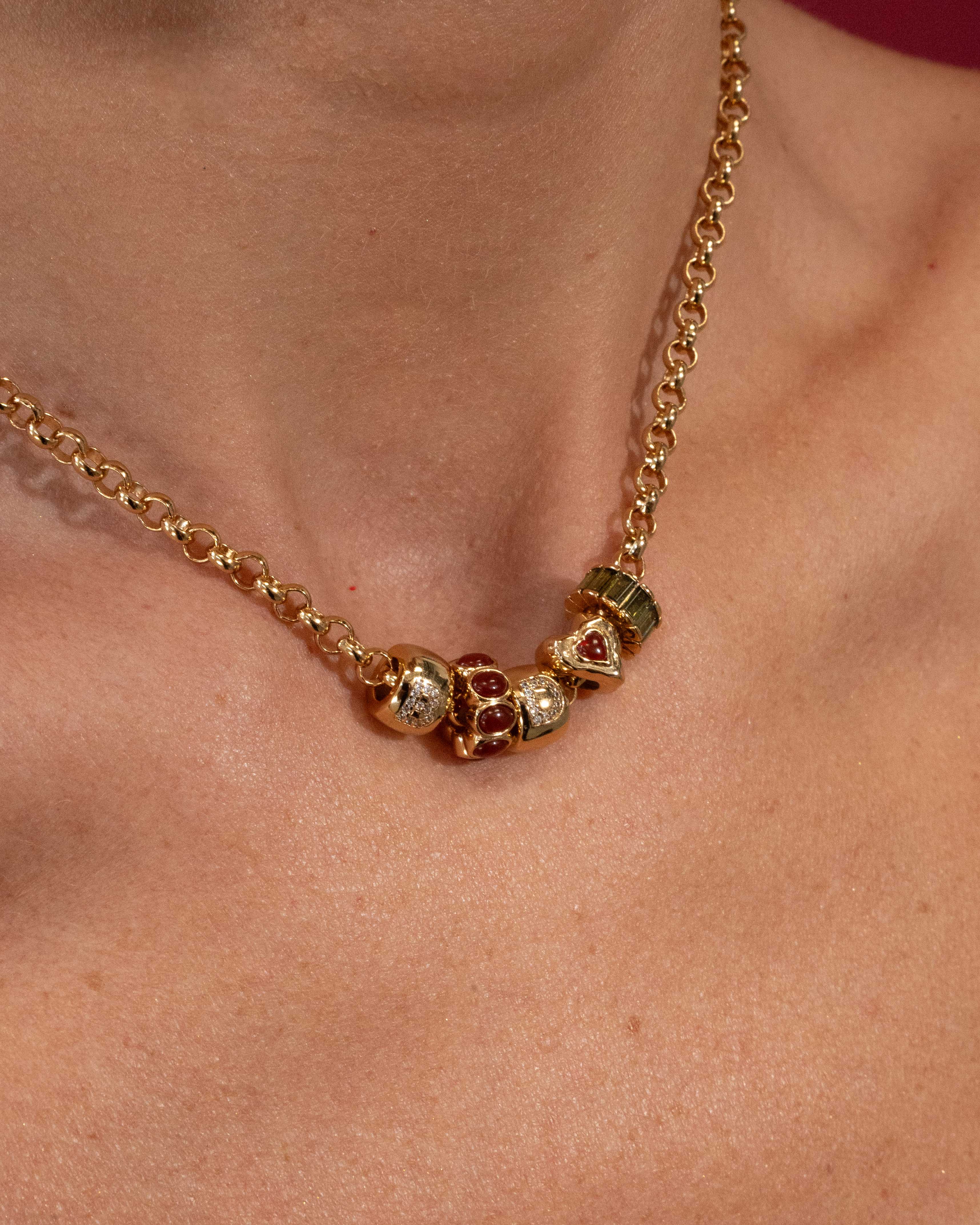 Gold necklace with colorful beads on a person's neck