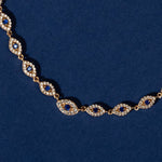 Necklace with blue gemstones and rose gold accents on a blue background