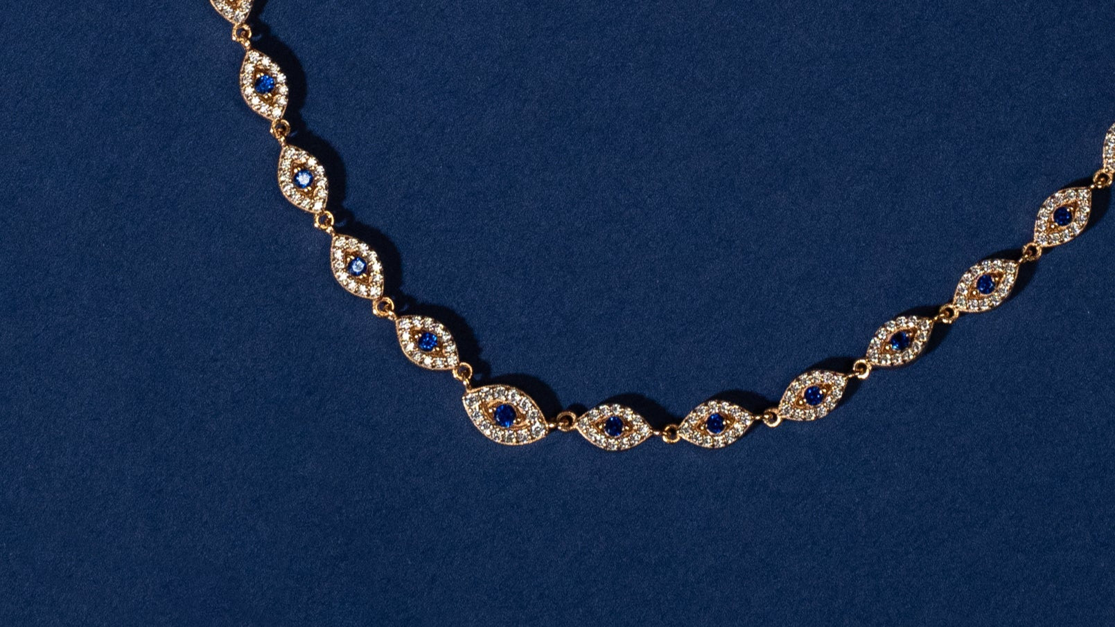 Necklace with blue gemstones and rose gold accents on a blue background