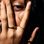 Close-up of a person covering their face with their hand with a fine ring