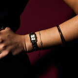 Close-up of a wrist wearing Fine Evil Eye Bracelets and a gold watch