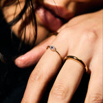 Close-up of a person's hand with a fine evil eye ring. 