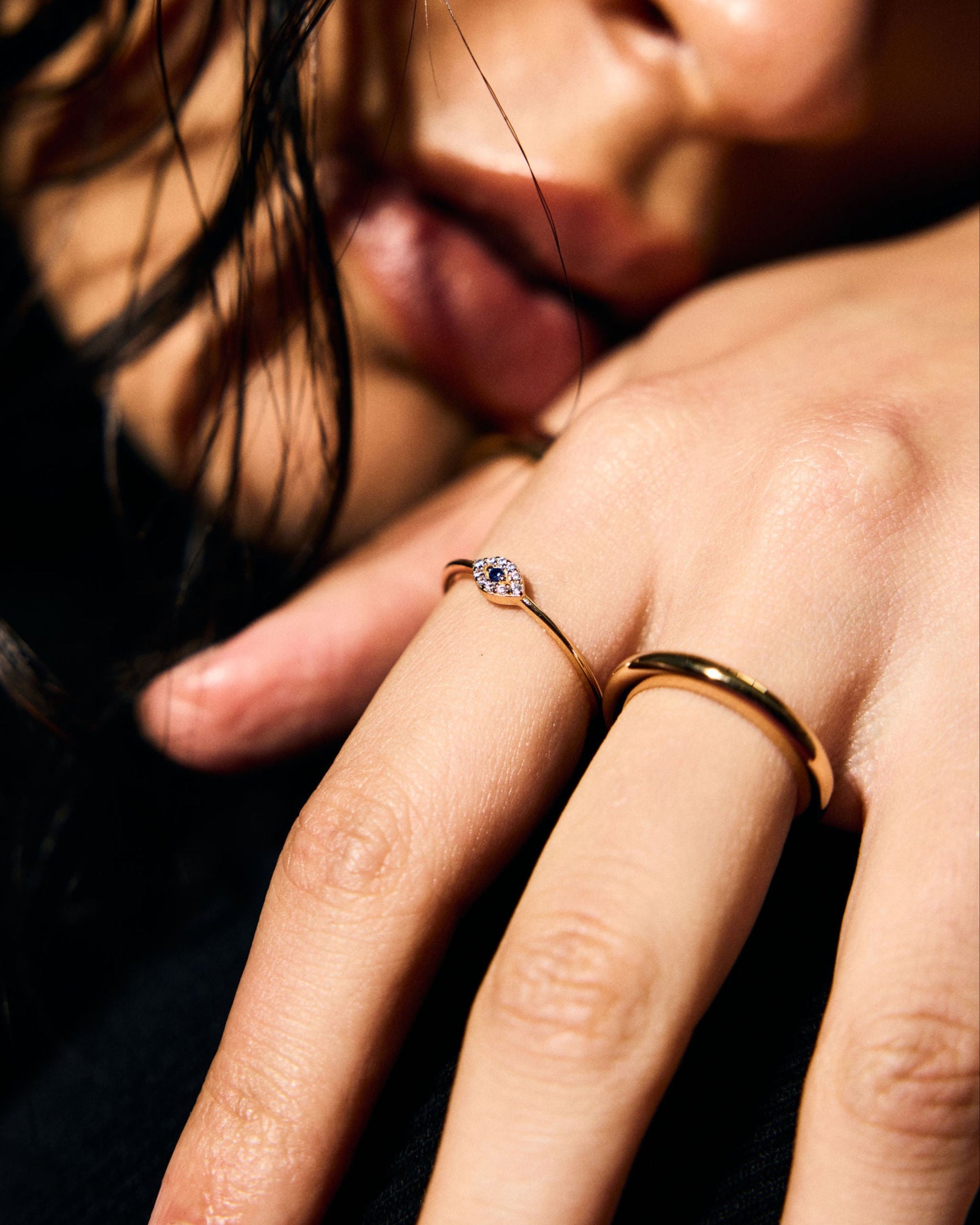 Close-up of a person's hand with a fine evil eye ring. 
