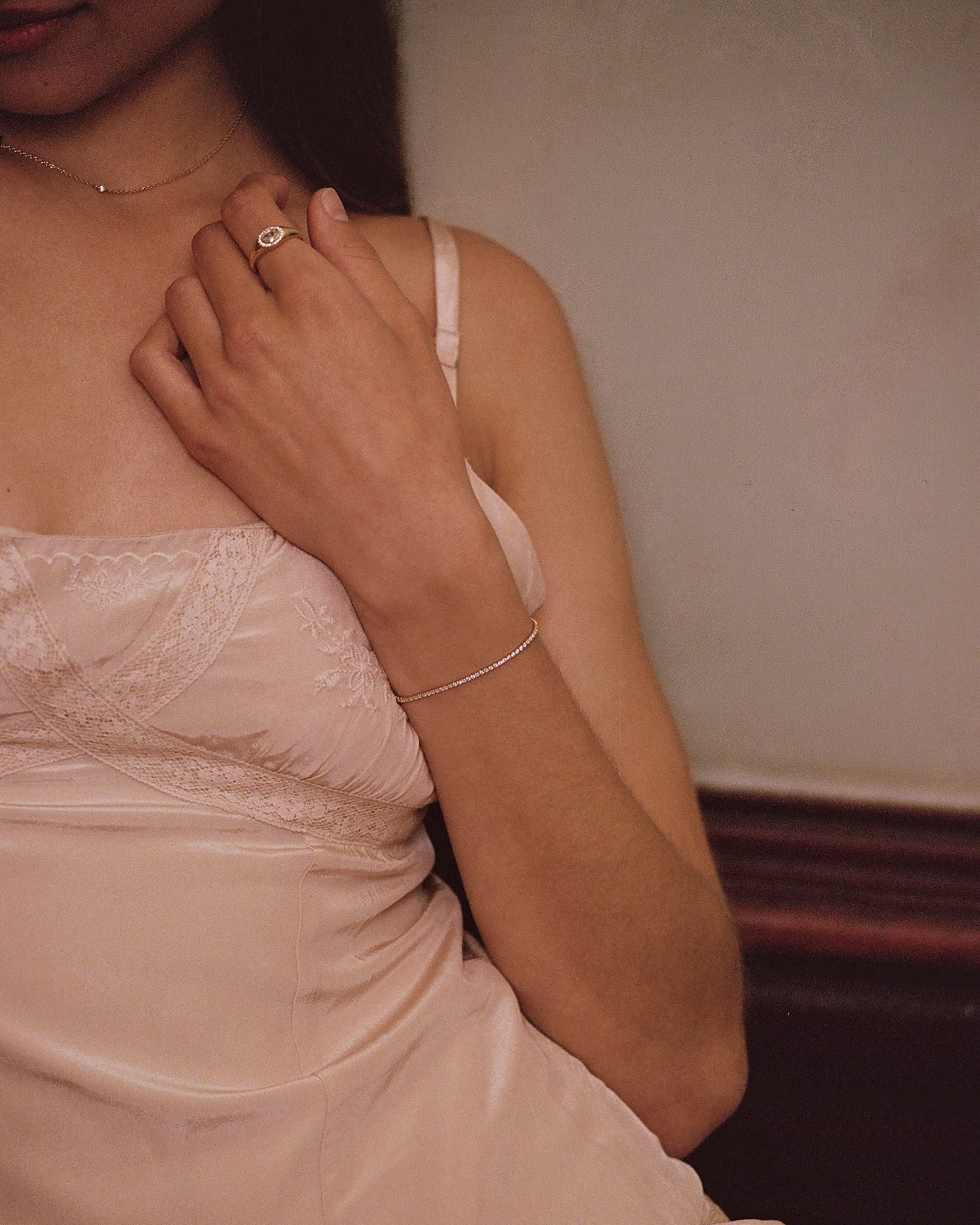 Woman in light pink dress wearing a tennis bracelet 