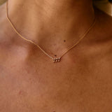 Close-up of a person wearing a delicate gold necklace with small pendants.