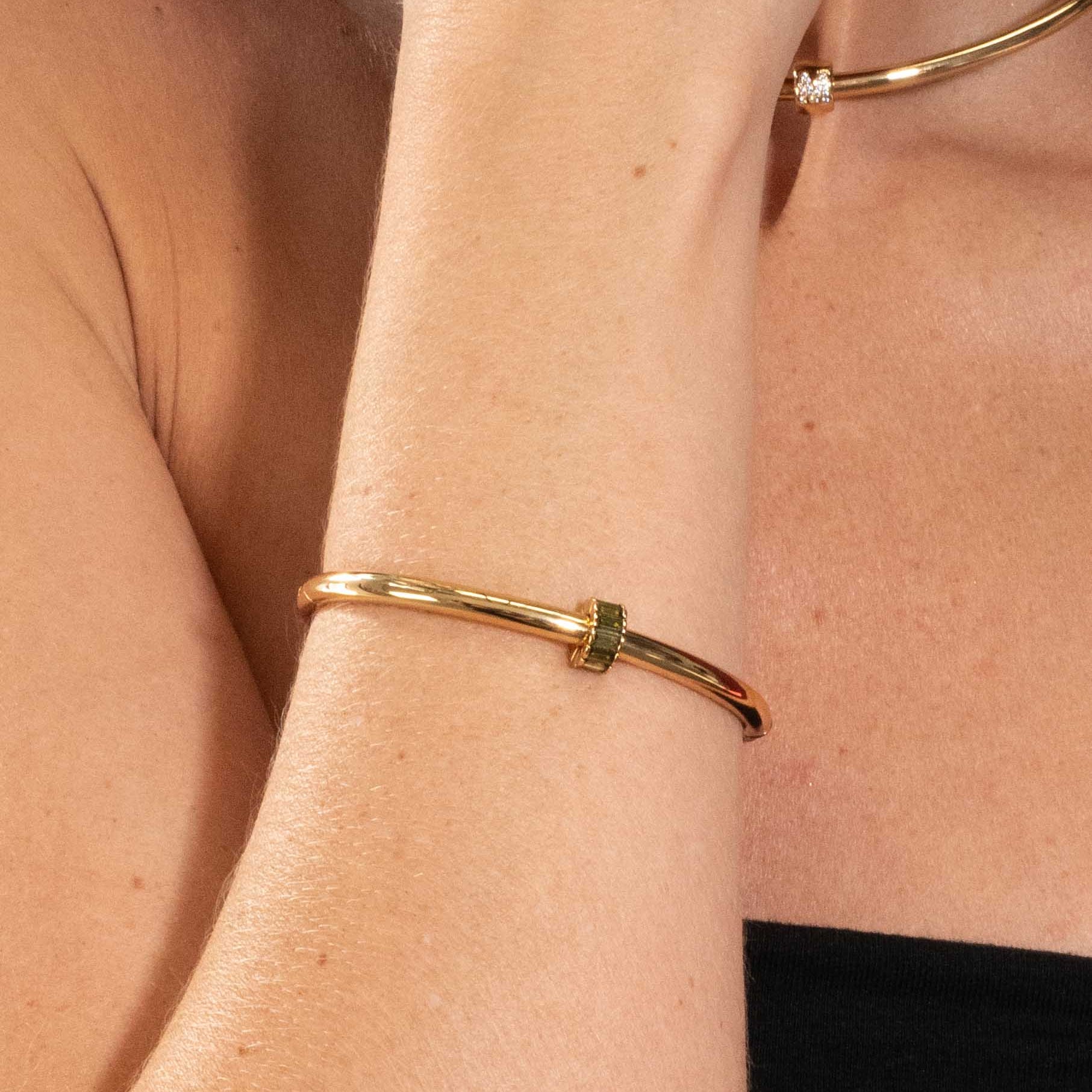 Gold bracelet on a person's wrist with a blurred background