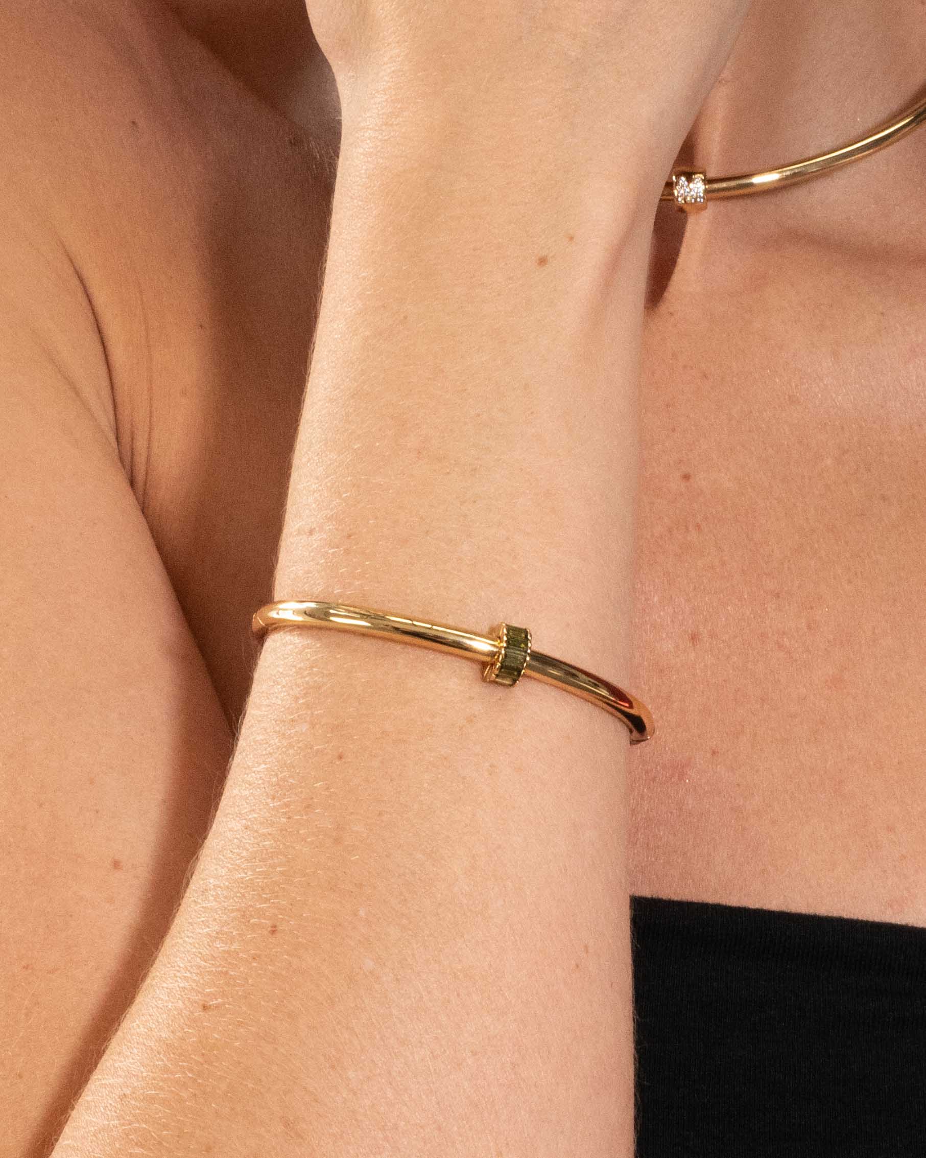 Gold bracelet on a person's wrist with a blurred background