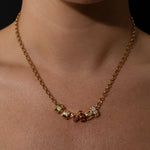 Gold Belcher necklace with beads on a person's neck against a black background