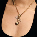 Gold necklace with a gold locket pendant on a person's neck 