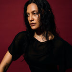 Woman wearing a black outfit against a red background
