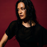 Woman wearing a black outfit against a red background