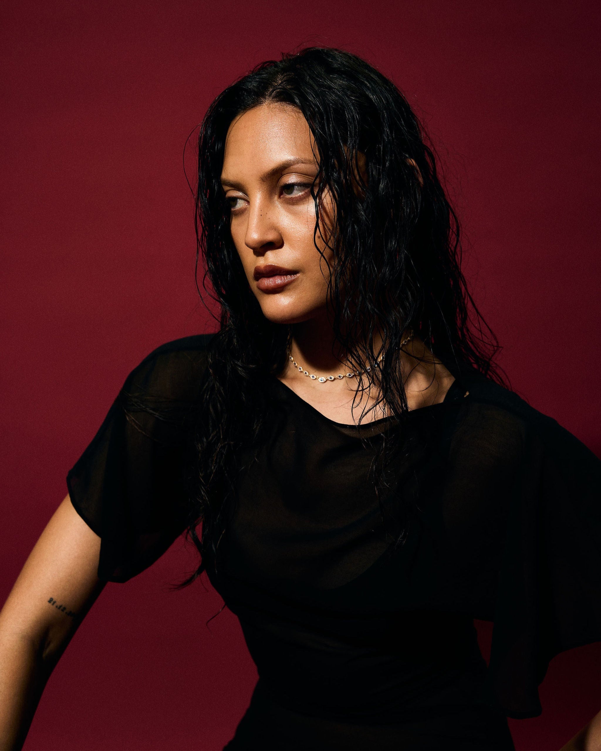 Woman wearing a black outfit against a red background