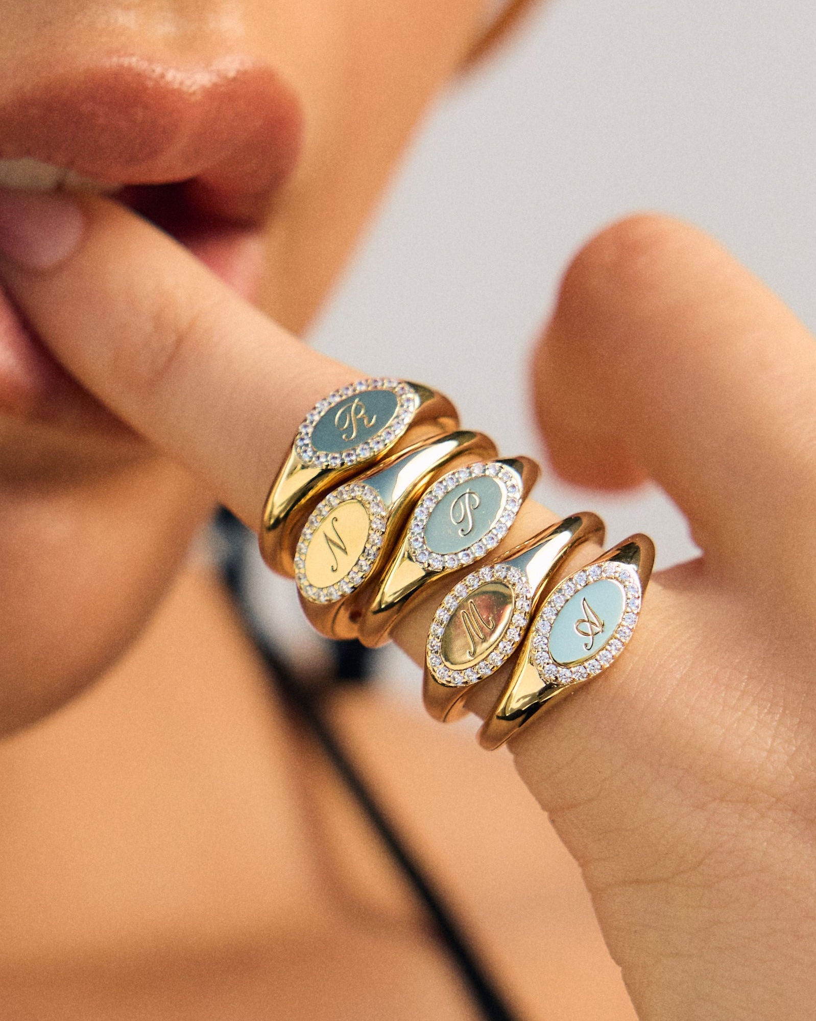 Close-up of a hand wearing multiple gold rings with gemstones.