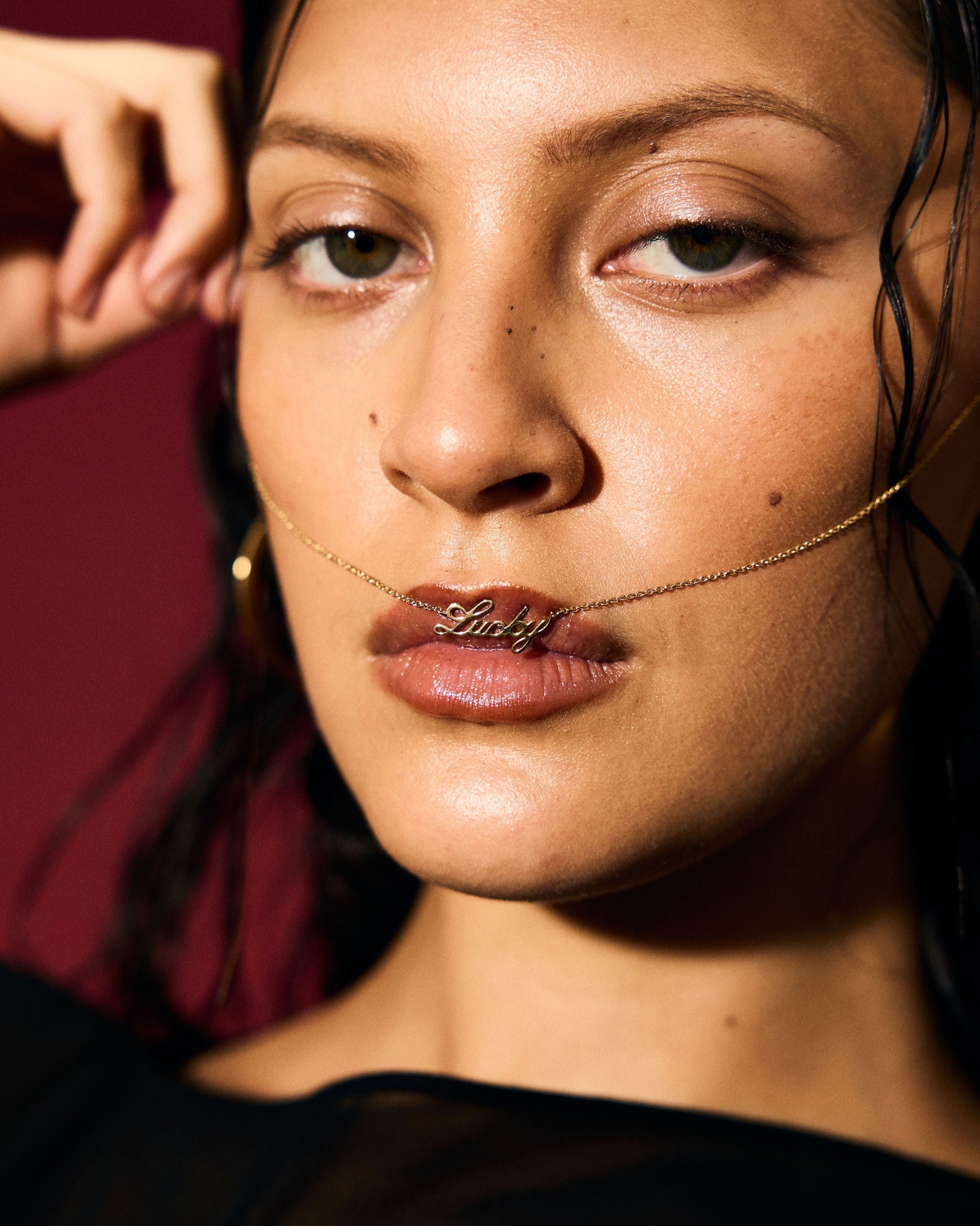 Close-up of a woman wearing a gold necklace with a pendant.