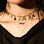 Close-up of a person wearing multiple gold necklaces with starfish and 'Lucky' pendant.
