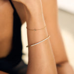 Close-up of a person's arm with gold stacked bracelets