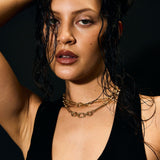 Woman wearing a black dress with a deep neckline against a dark background