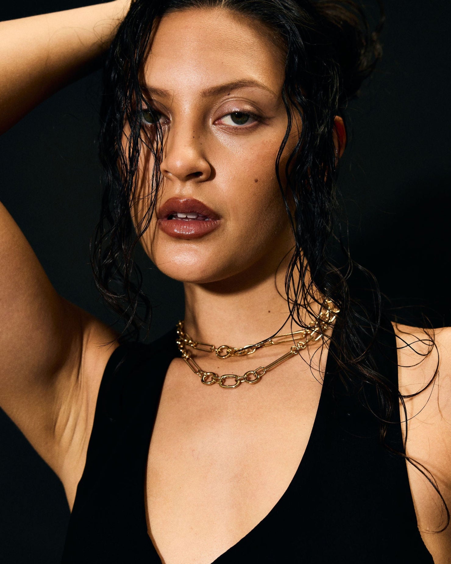 Woman wearing a black dress with a deep neckline against a dark background