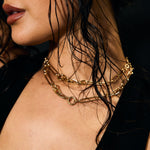 Close-up of a person wearing gold necklaces with a blurred background