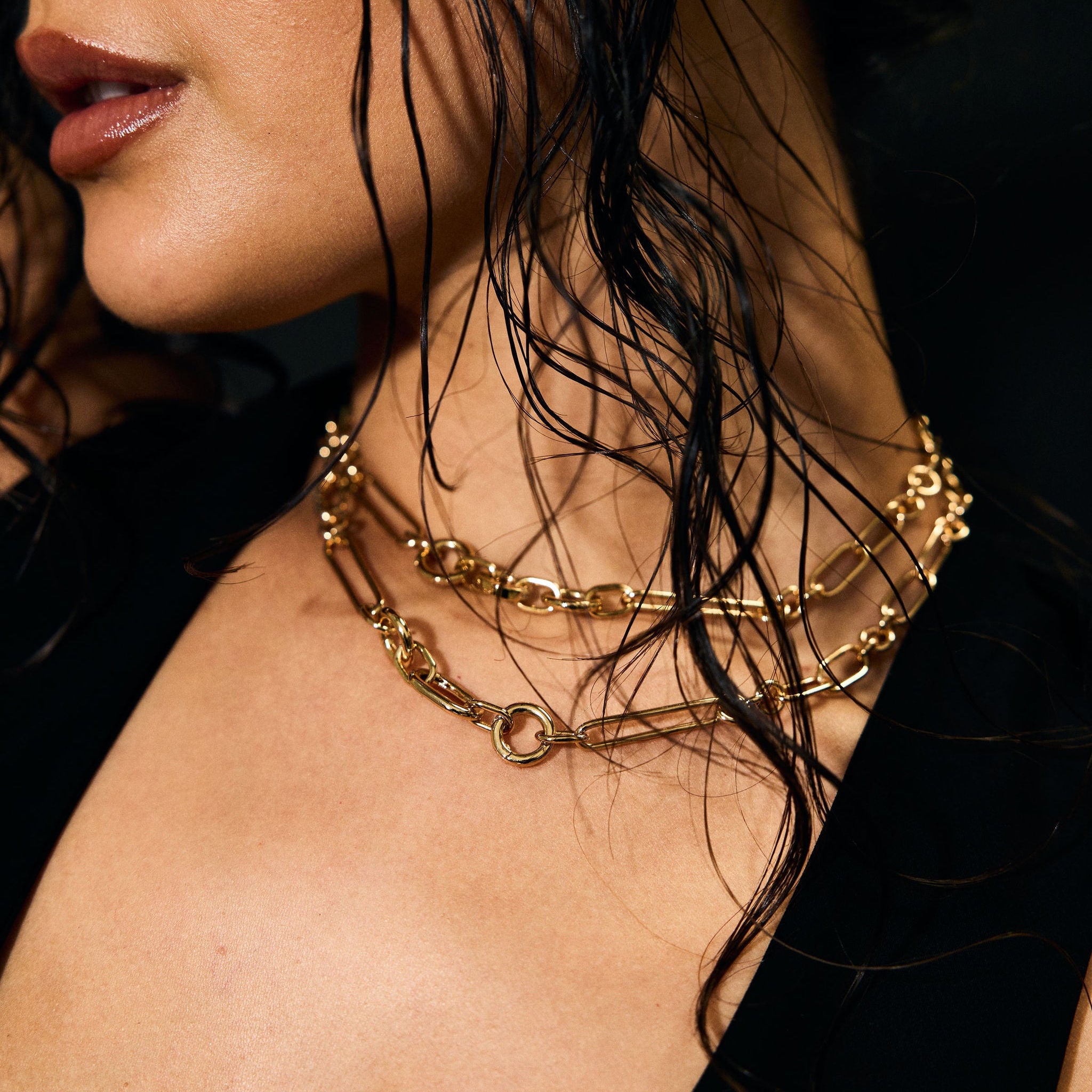 Close-up of a person wearing gold necklaces with a blurred background