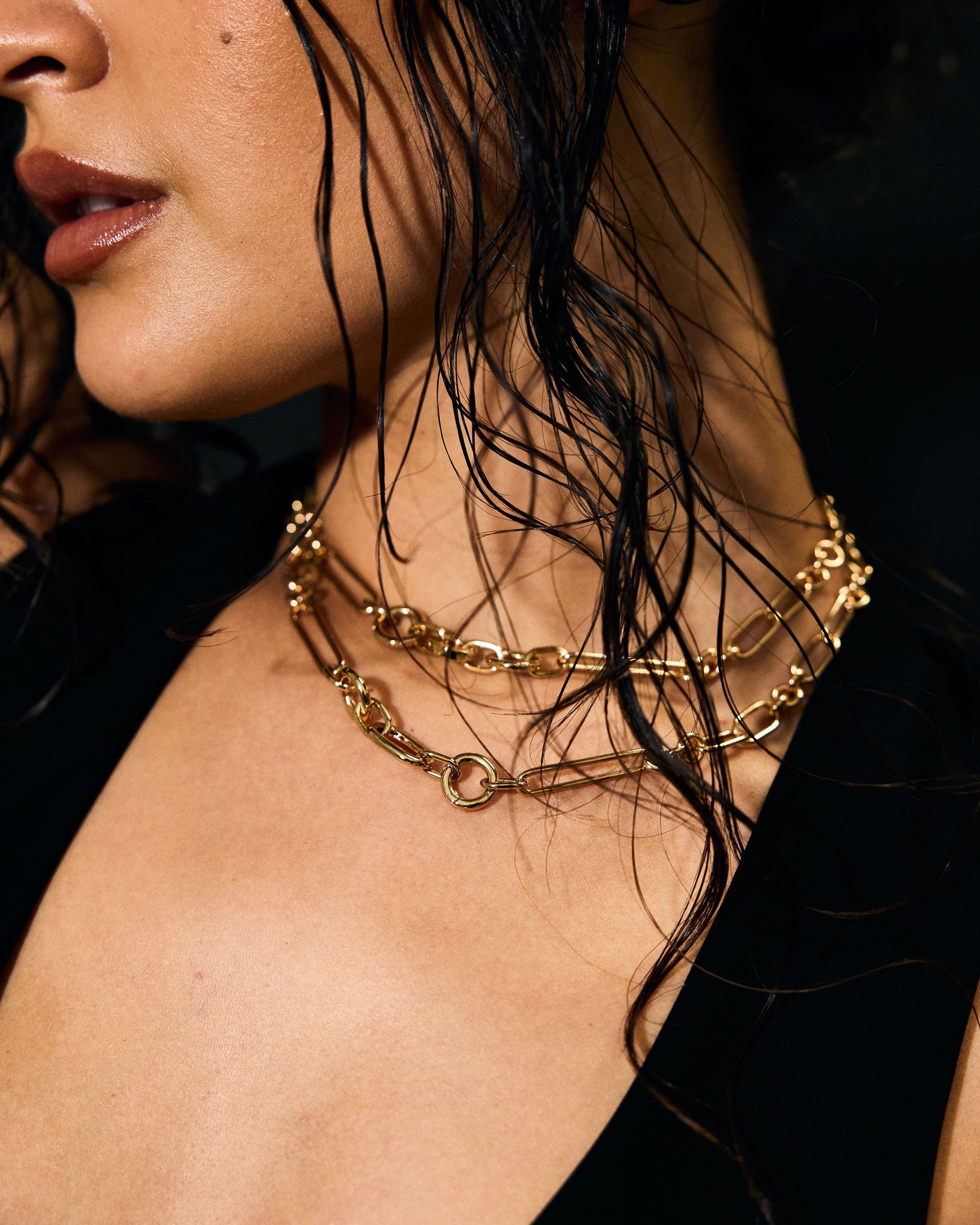 Close-up of a person wearing gold necklaces with a blurred background