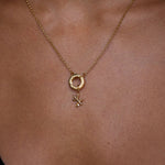 Gold necklace with a pendant on a person's neck