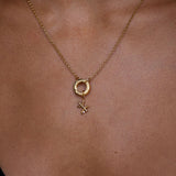 Gold necklace with a pendant on a person's neck