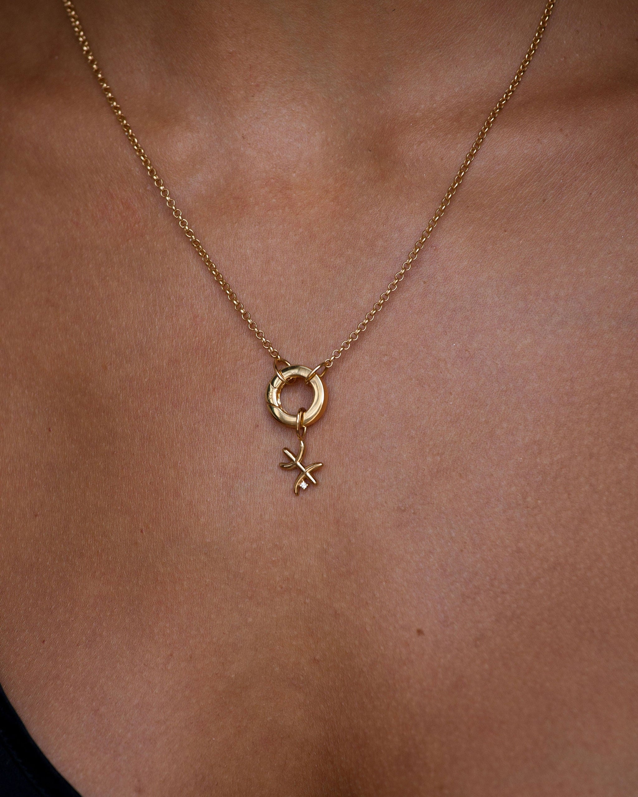 Gold necklace with a pendant on a person's neck