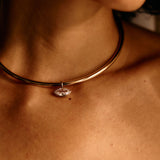 Necklace with a pendant worn by a person, close-up on skin.