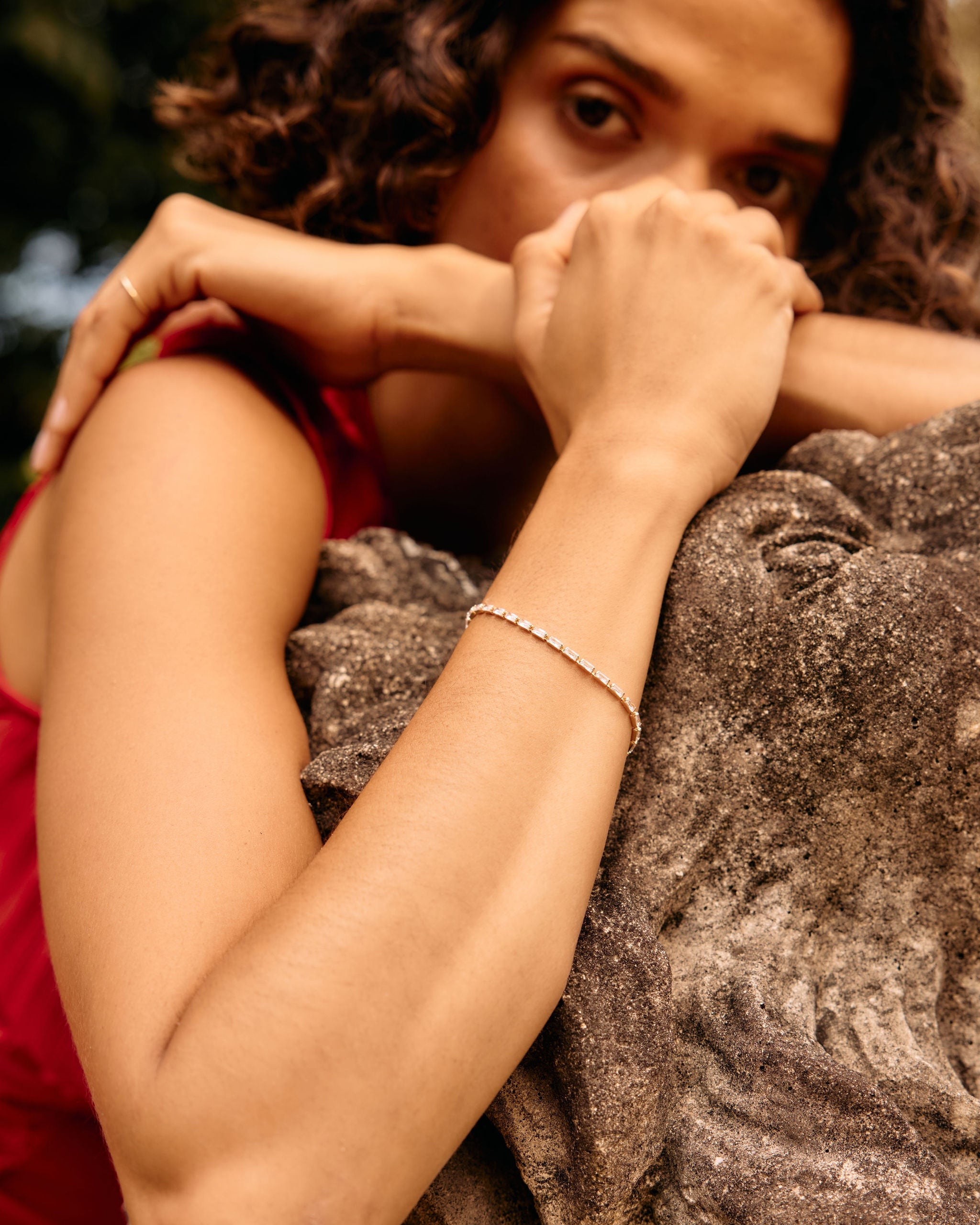 Woman in a red top embracing a stone sculpture