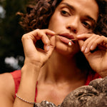 Woman with curly hair resting her chin on a stone surface outdoors