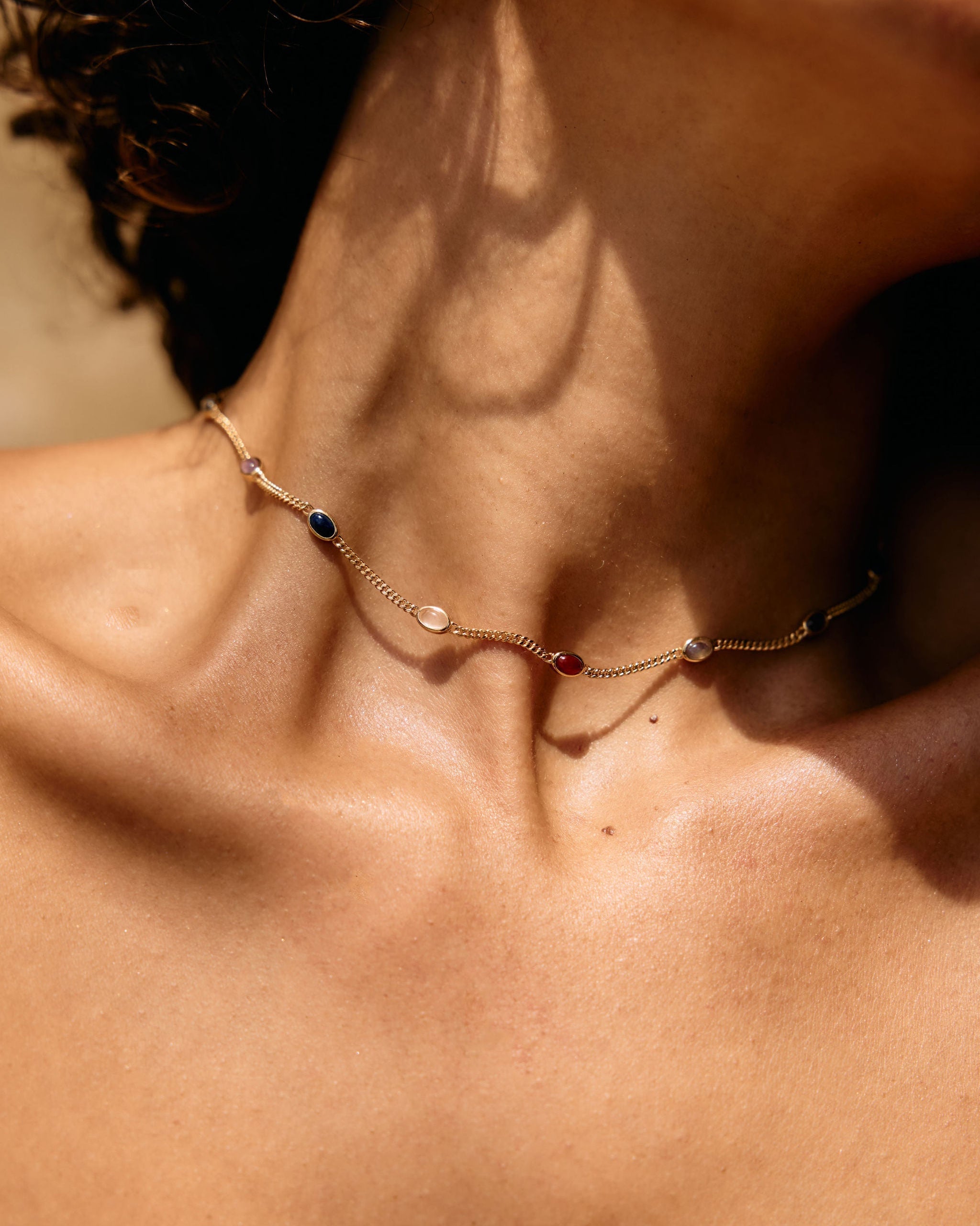 Necklace with small stones on a person's neck