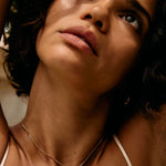 Close-up of a person with a necklace, with a blurred background