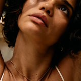 Close-up of a person with a necklace, with a blurred background