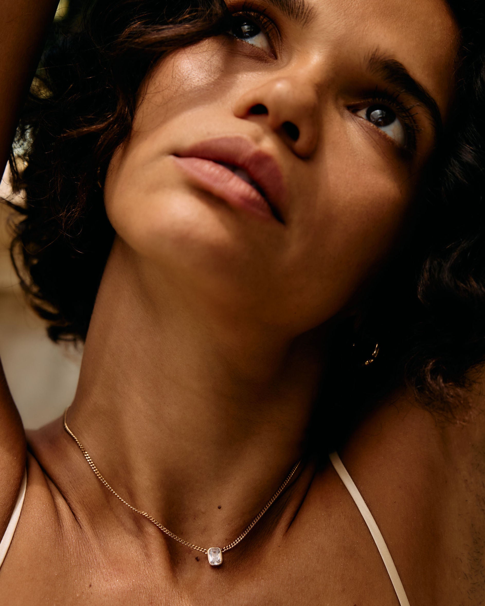 Close-up of a person with a necklace, with a blurred background