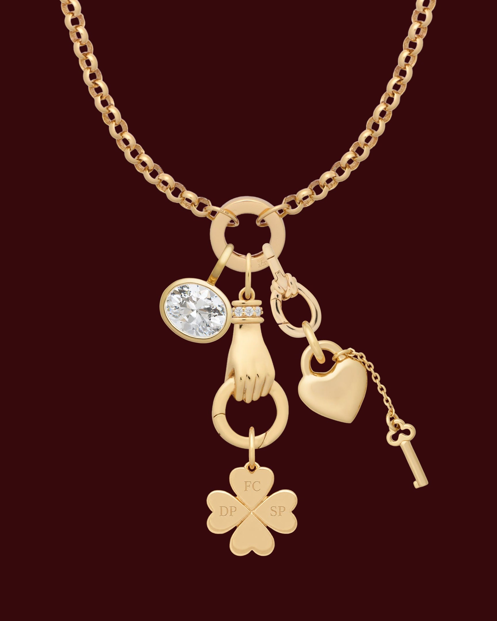 Gold necklace with various charms on a white background