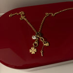 Gold necklace with charms on a red surface